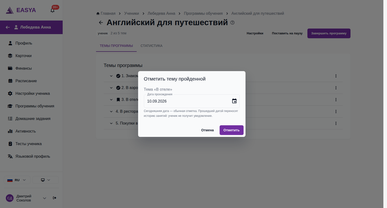Окно «Отметить тему пройденной» поверх назначенной программы: «Тема «В отеле»», поле «Дата прохождения» со значением 10.09.2026, подсказка «Сегодняшняя дата — обычная отметка. Прошедшей датой переносят историю занятий: ученик не получит уведомление.», кнопки «Отмена» и «Отметить».